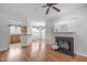 Bright living room featuring hardwood floors, a fireplace, and an open view to the kitchen at 232 Eyam Hall Ln, Apex, NC 27502
