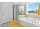 Bright bathroom featuring a separate shower and tub with light wood look tile at 2612 Nordmann Fir Rd, Raleigh, NC 27616