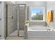 Bright bathroom featuring a separate shower and tub with light wood look tile at 2612 Nordmann Fir Rd, Raleigh, NC 27616