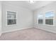 Bright bedroom with two windows, neutral carpet, and ample natural light at 2612 Nordmann Fir Rd, Raleigh, NC 27616