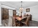 Spacious dining room with sliding barn door, hardwood flooring, and a modern chandelier above the table at 2612 Nordmann Fir Rd, Raleigh, NC 27616