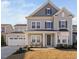 Charming two-story home featuring a gray color scheme, inviting front porch, and a convenient attached two-car garage at 2612 Nordmann Fir Rd, Raleigh, NC 27616