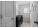 Bright laundry room featuring modern appliances, wood-look tile flooring, and ample storage at 2612 Nordmann Fir Rd, Raleigh, NC 27616