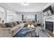 Bright living room with a comfortable sectional sofa, large windows, and a fireplace, perfect for relaxation at 2612 Nordmann Fir Rd, Raleigh, NC 27616