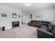 Inviting living room with plush carpeting and comfortable black leather sectional sofa at 2612 Nordmann Fir Rd, Raleigh, NC 27616