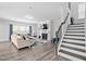 Cozy living room with fireplace, hardwood floors, and comfortable seating, flowing into the staircase at 2612 Nordmann Fir Rd, Raleigh, NC 27616
