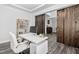 Office with luxury vinyl plank flooring, modern white desk with gold accents, shelving, and sliding barn door at 2612 Nordmann Fir Rd, Raleigh, NC 27616