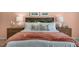 Elegant main bedroom showcasing a neatly made bed with wooden headboard, side tables and lamps, with a peach-colored wall at 273 Hawksmoore Ln, Lillington, NC 27546