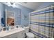 Bathroom with blue walls, and a blue and yellow striped shower curtain at 2815 Mebane Ln, Durham, NC 27703