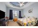 Bedroom with floral bedding, tray ceiling, and fan offers a relaxing retreat at 2815 Mebane Ln, Durham, NC 27703