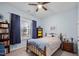 Cozy bedroom with natural light, a ceiling fan, and dark blue curtains at 2815 Mebane Ln, Durham, NC 27703