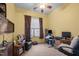 Bedroom with tan walls, a ceiling fan, natural light, and a dark leather chair at 2815 Mebane Ln, Durham, NC 27703