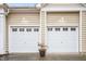 Attached two-car garage with white doors and exterior lighting at 2815 Mebane Ln, Durham, NC 27703