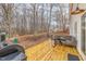 Backyard featuring a wooden deck, grill, playground, and a table with chairs surrounded by trees at 296 Trenburg Pl, Clayton, NC 27520