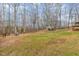Large backyard with mature trees, a playhouse, and outdoor furniture, ideal for relaxation and play at 296 Trenburg Pl, Clayton, NC 27520