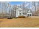 View of the two-story home from the yard, showcasing the large lawn and mature trees at 296 Trenburg Pl, Clayton, NC 27520