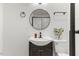 Well-lit bathroom featuring a sink, round mirror, and modern fixtures at 318 Fulton St, Burlington, NC 27217