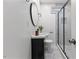 Modern bathroom with a vanity, round mirror, and marble-tiled shower with glass door at 318 Fulton St, Burlington, NC 27217