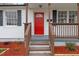 This is a charming front entrance with a red front door and a welcoming porch at 318 Fulton St, Burlington, NC 27217