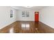 Bright living room featuring hardwood floors, large windows, and a vibrant red front door at 318 Fulton St, Burlington, NC 27217