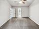 Empty bedroom featuring neutral walls, gray carpet, and a view of a hallway with hardwood floors at 4205 Rockside Hills Dr, Raleigh, NC 27603