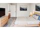 Bright main bedroom featuring a light wood frame bed, neutral walls, and hardwood floors in the hallway at 4205 Rockside Hills Dr, Raleigh, NC 27603