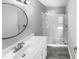 Bathroom boasts a walk-in shower with glass door, modern vanity, and round mirror above the sink at 4213 Sunscape Ln, Raleigh, NC 27613