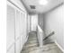 Hallway features laminate floors, two sets of closet doors, and a staircase with a wood handrail at 4213 Sunscape Ln, Raleigh, NC 27613
