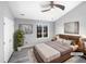 This bright main bedroom features a ceiling fan, a window with wooded view, and an ensuite bathroom at 4213 Sunscape Ln, Raleigh, NC 27613