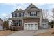 Charming two-story home with a stone facade, inviting porch, and a three-car garage, offering both elegance and practicality at 464 Granite Saddle Dr, Rolesville, NC 27571