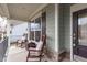Charming front porch with rocking chairs, a side table, and dark-stained door at 464 Granite Saddle Dr, Rolesville, NC 27571
