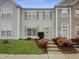 Charming townhouse with manicured lawn, colorful bushes, and inviting light green front door at 5107 Tomasita Ct, Raleigh, NC 27616