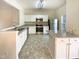 A well-lit kitchen featuring stainless steel appliances, white cabinets, and granite countertops at 5107 Tomasita Ct, Raleigh, NC 27616