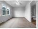 A bright bedroom featuring a ceiling fan and a door to the ensuite bathroom at 516 Caprice Ct, Raleigh, NC 27606