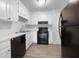 Well-lit kitchen features white cabinets and modern black appliances at 516 Caprice Ct, Raleigh, NC 27606