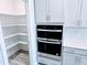 Kitchen showing double oven, pantry, and white cabinets and countertops at 5849 Genesee Dr., Homesite 3, Durham, NC 27712