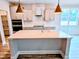 Bright kitchen with island, white cabinets, pendant lights, stainless appliances, and double oven at 5849 Genesee Dr., Homesite 3, Durham, NC 27712