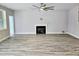 Spacious living room featuring a fireplace, luxury vinyl plank flooring and neutral paint at 5849 Genesee Dr., Homesite 3, Durham, NC 27712