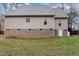 Back exterior of home featuring siding, brick foundation, and access door at 589 Vinson Rd, Clayton, NC 27527