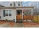 Inviting front entrance with covered porch and charming wooden fence detail at 589 Vinson Rd, Clayton, NC 27527