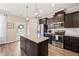Stylish kitchen boasts a large granite island, stainless steel appliances, and dark wood cabinetry at 5908 Giddings St, Raleigh, NC 27616