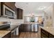 Modern kitchen with stainless steel appliances, granite countertops, and an open view to the living room at 5908 Giddings St, Raleigh, NC 27616