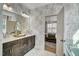 Stylish bathroom with a double vanity, elegant wallpaper, and bedroom access at 67 Rice Road # 01, Zebulon, NC 27597