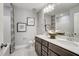Bathroom featuring double vanity sinks, a tub with shower, and wall art at 67 Rice Road # 01, Zebulon, NC 27597