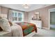 Bright bedroom featuring a large window, neutral walls and trim, and a decorative mirror and chest of drawers at 67 Rice Road # 01, Zebulon, NC 27597