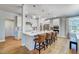 Bright, white kitchen features a large island with seating, pendant lighting, and stainless steel appliances at 67 Rice Road # 01, Zebulon, NC 27597