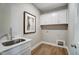 Bright laundry room with cabinets, sink, and modern fixtures at 67 Rice Road # 01, Zebulon, NC 27597