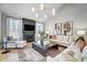 Bright living room featuring a fireplace with mounted TV, neutral furniture, and a modern light fixture at 67 Rice Road # 01, Zebulon, NC 27597
