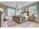 Bright main bedroom with a tufted headboard, chandelier, large windows, and decorative rug at 67 Rice Road # 01, Zebulon, NC 27597