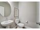 Chic powder room featuring a pedestal sink, modern toilet, and stylish round mirror at 67 Rice Road # 01, Zebulon, NC 27597